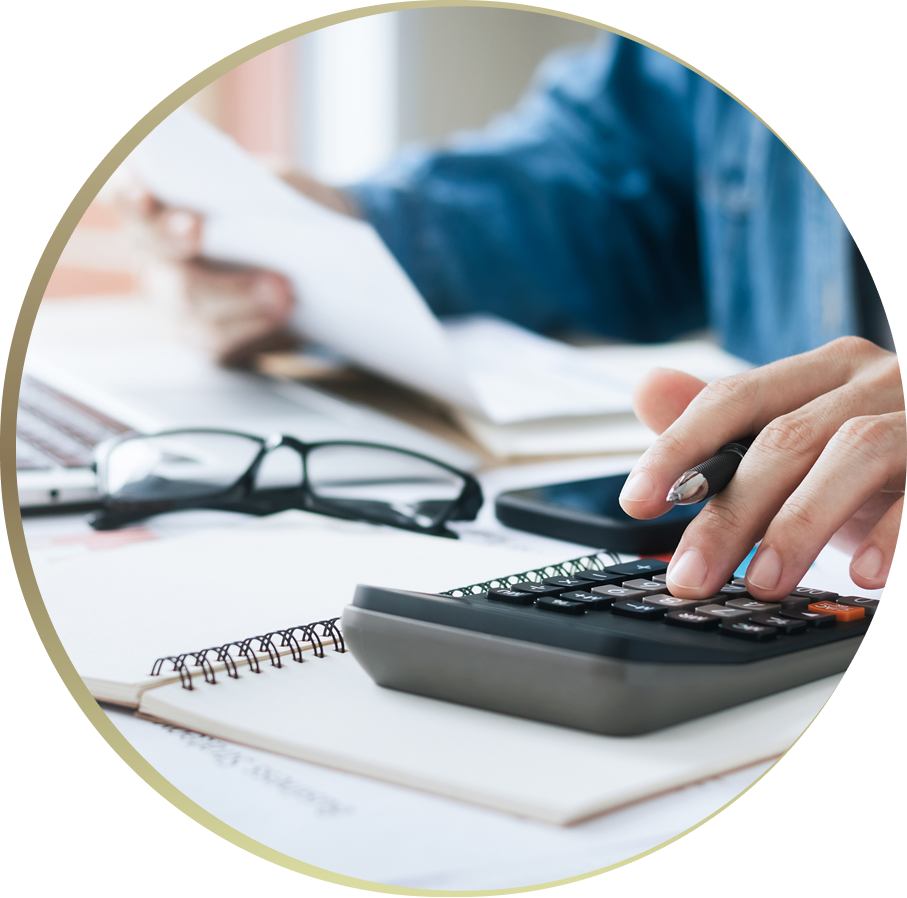 Person using calculator with documents and glasses.
